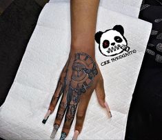 a woman's hand with tattoos on it and a panda face tattooed on the wrist