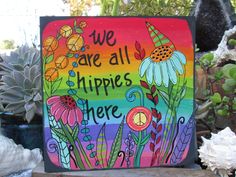 a painted sign that says we are all hippies here