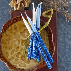 three blue and white candles on a brown plate