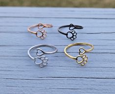 This is a really cute, adjustable stainless steel ring. It has a paw print on one side and a heart on the other. You can choose from 4 colors: silver, gold, black, or rose gold.  I would say this is adjustable from a size 6 to a size 10. Each item will be sent to you in a gift bag or box. This is perfect for anyone! Birthdays, anniversaries, jewelry for bridesmaids, gifts for Mom, or any other occasion. Please contact me if you have any custom requests or questions. Shipping is typically 4 to 6 Color Gifts, Paw Print Ring, Rose Noir, Birthday Mom, Stainless Steel Rings, Bridesmaids Gifts, Steel Ring, Rings Statement, Gold Rose