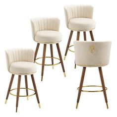 four white bar stools with wooden legs and gold trim around the footrests