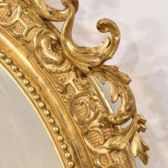 an ornate gold framed mirror against a white wall