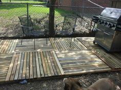 a dog laying on the ground next to a grill