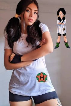 a woman with her arms crossed standing in front of a cartoon character wearing shorts and t - shirt