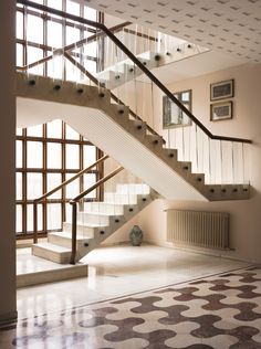 the front page of a magazine with stairs and tiled flooring in white, beige and black