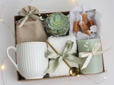 a box filled with assorted items on top of a white table next to string lights