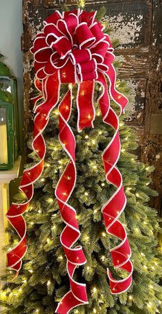 a christmas tree decorated with red and white ribbons