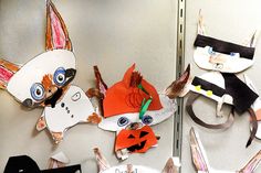 several paper animals are hanging on the wall in front of a mirror with scissors and other items