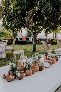 the table is set up with candles and vases on it for an outdoor function