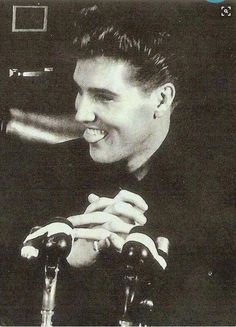 a black and white photo of a man sitting at a table with a wine glass in his hand