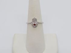 Vintage Sterling Silver Garnet & White Topaz Hamsa Ring ....Marked 925...Total of weights 1.7grams...Size 7...Measure of Face 10.9MM...It's in very good condition. Hand Set White Gold Diamond Ring As Gift, Silver Oval Diamond Ring With Hand Set, White Gold Sterling Silver Ruby Ring With Diamond Accents, Silver Ruby Ring With Diamond Accents As Gift, Adjustable White Gold Diamond Ring With Gemstone, Silver Rings Hand Set For Gift, Hand Set Sterling Silver Diamond Ring, Silver Ruby Ring With Diamond Accents, Hand Set Sterling Silver Promise Ring