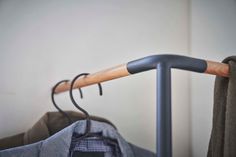 a coat hanger with clothes hanging on it's side, next to a pair of jeans