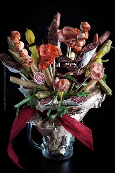 a vase filled with lots of different types of food on top of a black table