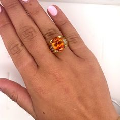 GIA Certified Unisex Ring in 18K Yellow Gold, weighing 14.90 grams, boasting a 13.5 carat oval cut Spessartine Garnet center stone. The vibrant orange gem is superbly clean and lustrous. Exploding with color and brilliance. Adorned with 16 princess cut diamond side stones, totaling 0.96 carats.  This Spessartine Garnet is extremely rare due to its rich Mandarine Orange color, lack of inclusions, and 13.5 carat size.   Item Details: - Type: Unisex Ring  - Metal: 18K Yellow Gold  - Weight: 14.90 Grams  - Setting: 4-Prong  - Size: 7.5 (adjustable) - Mounting: 17 MM elevation  ___________________________  Center Stone Details: - Type: Spessartine Garnet  - Carat: 13.5  - Cut: Oval-Brilliant - Color: Mandarine Orange  - Measurements: 14.24 x 10.75 x 8.08 MM   GIA Certificate #: 6234022072  GIA Luxury Orange Gemstone Accented Jewelry, Luxury Orange Jewelry With Gemstone Accents, Luxury Orange Gemstone Jewelry, Fine Jewelry Orange Oval, Fine Jewelry Orange Oval Jewelry, Luxury Orange Gemstone Ring, Oval Orange Polished Jewelry, Orange Oval Jewelry With Polished Finish, Luxury Orange Oval Jewelry