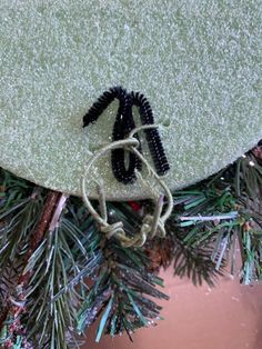 a black and white bug on top of a green christmas tree