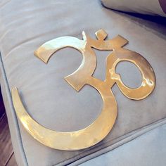 a gold omen symbol sitting on top of a blue couch