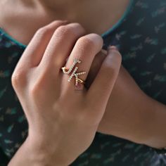 a close up of a person wearing a ring with an arrow on it's middle finger