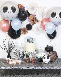 a table topped with lots of balloons and cake