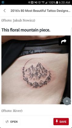 a small tattoo on the side of a woman's stomach with mountains in the background