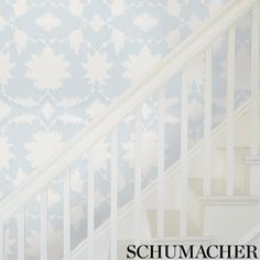 a white staircase with blue and white wallpaper