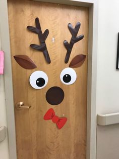 a door decorated to look like a reindeer with antlers on its head and bow tie