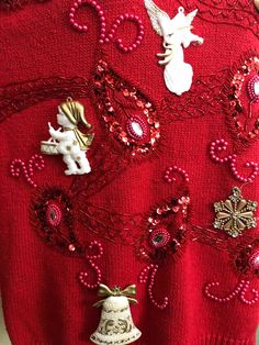 a red sweater with christmas decorations and bells on the front is shown in close up