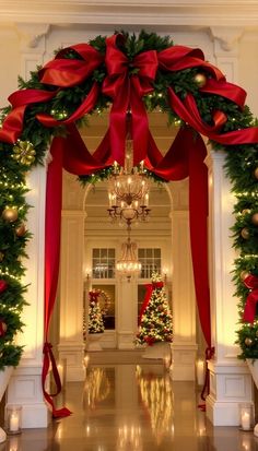 the entrance to a building decorated for christmas with red bows and garlands on it