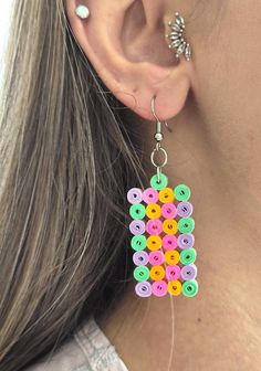 a close up of a person wearing earrings with buttons on it's back end