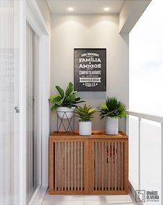 two plants are sitting on top of a wooden cabinet in front of a white wall