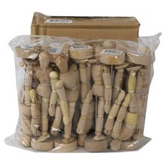 several wooden mannequins are wrapped in plastic