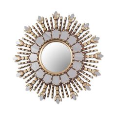 a mirror that is sitting on top of a white wall with gold trimmings