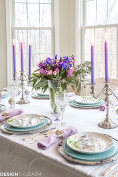 the table is set with plates and place settings