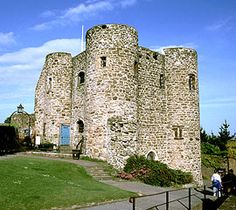 an old stone castle sitting on top of a lush green field