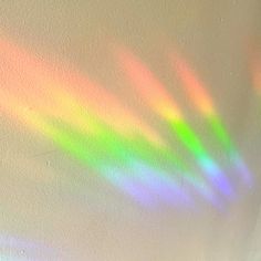 the sun is shining brightly through the rainbow colored window pane in an empty room