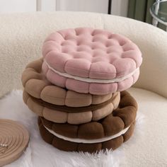 a stack of pillows sitting on top of a white chair next to a round object