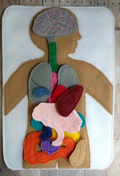 an image of a child's body made out of felt and felt flowers on a piece of cloth