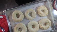 doughnuts sitting on top of a baking sheet with a fork next to them