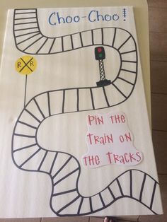 a child's hand holding up a sign that says choo choo pin the train on the tracks