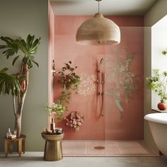 a bathroom with pink walls and plants in the shower area, along with a white bathtub