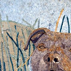 a dog is depicted on a mosaic tile wall with grass and reeds in the background