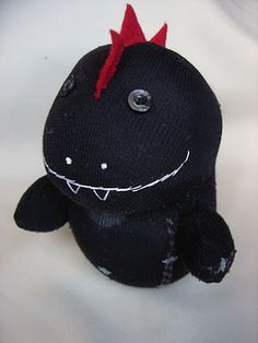 a black stuffed animal with red spikes on it's head