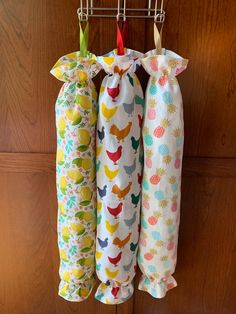 three baby swaddles hanging from a hook