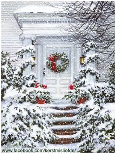 a white house covered in snow with wreaths on the front door and steps leading up to it