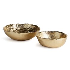 two gold bowls sitting next to each other