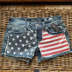 an american flag patchwork jean shorts is displayed in front of a wicker basket