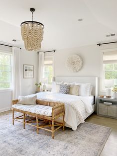 a bedroom with a large bed and chandelier hanging from it's ceiling