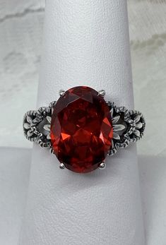 "Red Garnet CZ Ring Ace-Oval Design#92 Custom Made I now offer this lovely Gothic/Renaissance inspired ring in sterling silver. This gorgeous ring is set with a flawless Red Garnet Cubic Zirconia gemstone. The full cut 5ct oval cut gemstone is 14mm (9/16th of an inch) Long by 10mm Wide (3/8th\"). The ring sits 7mm off the finger. The inside of the band Is marked 925 for sterling. Notice the beautiful leaf-like design of the filigree setting. A ring box is included for safe keeping. Feel free to Victorian Red Oval Filigree Ring, Oval Ruby Ring With Cubic Zirconia For Formal Occasions, Formal Oval Ruby Ring With Cubic Zirconia, Oval Ruby Ring With Stone Setting, Red Oval Filigree Ring For Anniversary, Red Oval Filigree Ring For Formal Occasions, Oval Filigree Ring With Accent Stones For Formal Occasions, Red Ruby Oval Filigree Ring, Oval Ruby Filigree Ring In Red