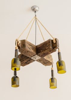 a chandelier made out of wooden planks with yellow glass shades hanging from the ceiling