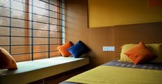 two beds in a small room with wooden blinds