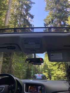 the dashboard of a car with trees in the background